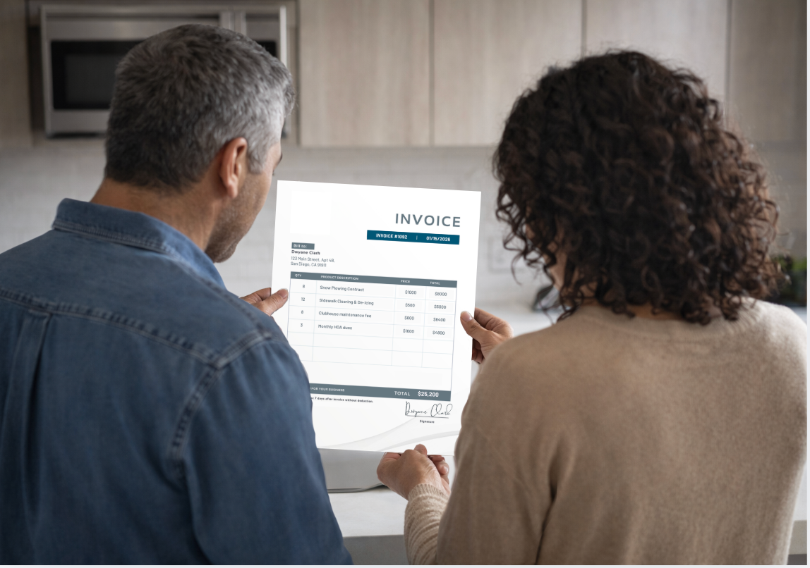 couple standing in kitchen looking at invoice
